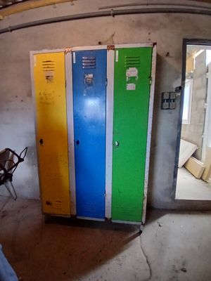 trois casiers dans une pièce équipée d'une chaise et d'une table