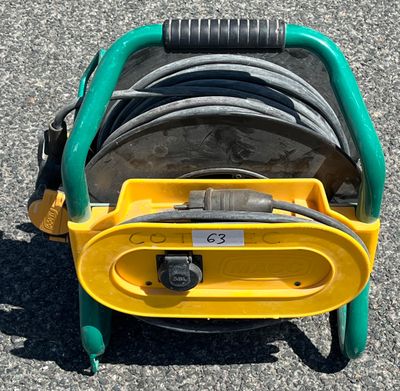 un chariot à tuyaux d'incendie jaune et vert, équipé de tuyaux