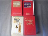 trois livres posés sur une table, avec une bouteille de vin devant eux