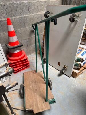 a hand truck with a wooden board on it in a garage