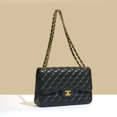 un sac Chanel noir muni d'une bandoulière en chaîne dorée