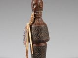 figurine en bois représentant une femme portant un chapeau et une canne