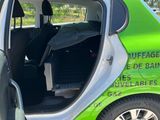 a small green car with its door open and the door open