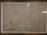 un vieux dessin représentant un plan, encadré et accroché au mur