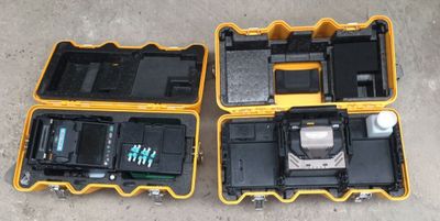 deux valises jaunes et noires contenant du matériel électronique, posées par terre