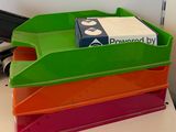 a stack of four plastic bins on a desk