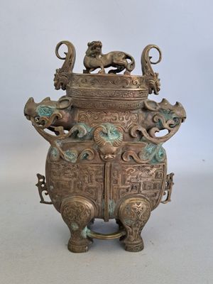 an old bronze urn with two lions on top of it