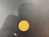 a close up of a gold coin on a black surface