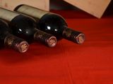 several bottles of wine are lined up on a red table cloth