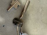 two keys and a heart shaped keychain on the floor