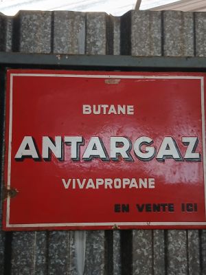 a red sign that says antarcaal on the side of a building