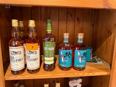 de nombreuses bouteilles d'alcool posées sur une étagère dans un meuble en bois