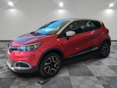 une voiture rouge est garée dans une pièce au sol en damier