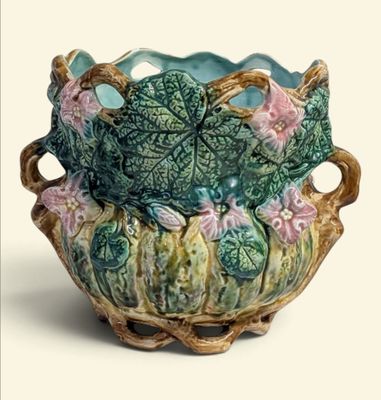 un vase vert contenant des fleurs roses, sur fond blanc