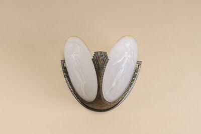 a picture of a wall sconce with two white eggs on it