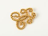 a close up of a gold necklace on a white surface