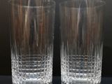 pair of crystal tumblers on a table with a black background