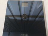 a glass bathroom scale with a clock on top of it