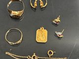 several gold rings, bracelets, and other jewelry on a table