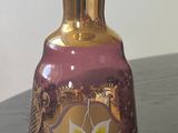 a purple and gold vase sitting on a black table