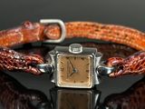 an image of a wrist watch with a brown leather band on a black surface