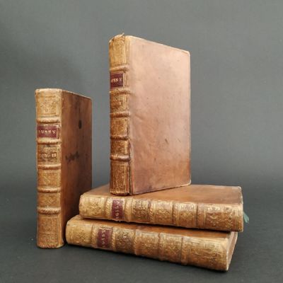 several old books are stacked on top of each other on a table