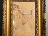 une image représentant une photo d'une rue, dans un cadre doré