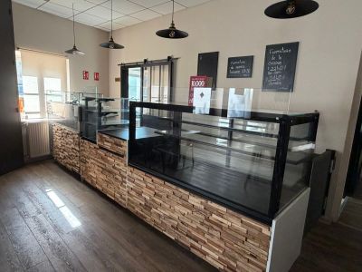 une photo du comptoir d'une boulangerie avec une vitrine en verre