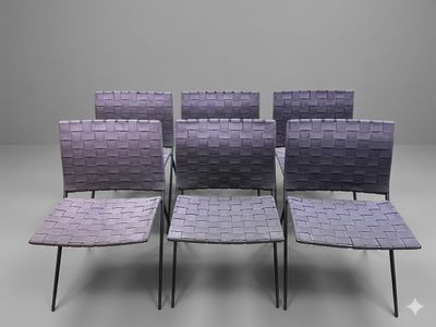 four chairs with woven seats are arranged in a row on a gray surface