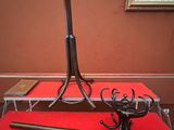 une table rouge avec un piètement en métal, sur laquelle est posée une batte de baseball