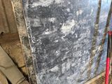 un gros morceau de marbre posé par terre, à côté d'un tas d'autres objets