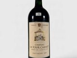 a bottle of red wine sitting on top of a white table