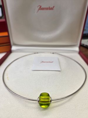 une perle de verre verte se trouve dans une boîte posée sur une table