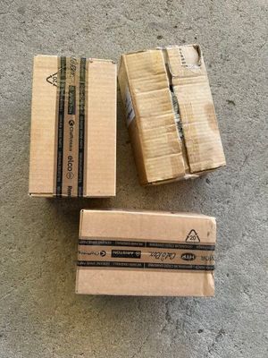 Trois cartons sont empilés les uns à côté des autres sur le sol.