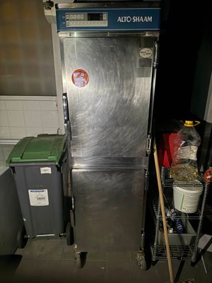 un réfrigérateur argenté au milieu d'une cuisine sale