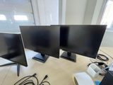 three computer monitors sitting on a desk next to each other