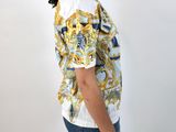the back of a woman wearing a white shirt with a yellow and blue pattern