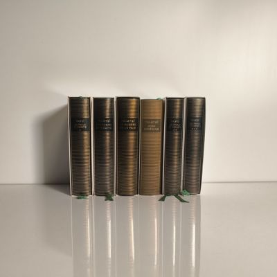 quatre livres sont alignés sur une surface blanche