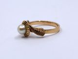 an image of a gold ring with a pearl in the middle