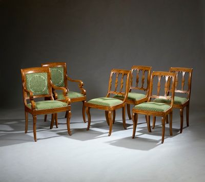 four wooden chairs with green upholstered upholstered cushions in a dark room