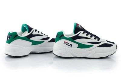 une paire de baskets blanches et vertes posées sur une surface blanche