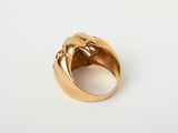 a close up of a gold ring on a white surface