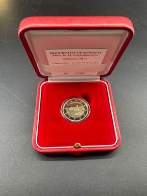 a red box with a gold coin in it on a table