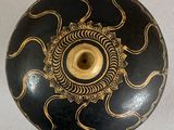 a black and gold vase with a gold design on it