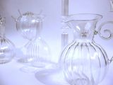 several clear glass vases are lined up on a white surface