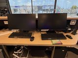 un bureau sur lequel sont posés deux écrans d'ordinateur et un clavier