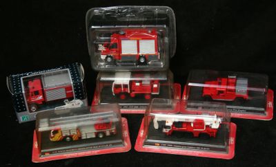 quatre camions de pompiers rouges et blancs dans des boîtes en plastique