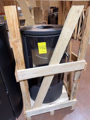 a black trash can sitting on a wooden stand in a warehouse