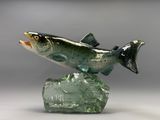 sculpture représentant un poisson perché sur un rocher, posée sur une surface grise