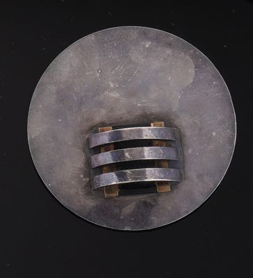 une photo d'un objet métallique posé sur une surface noire